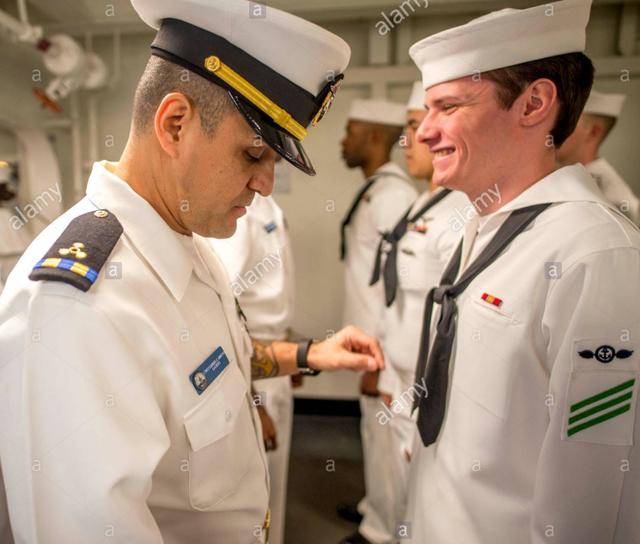这是一名美国海军二级准尉给一名二等水兵整理着装.