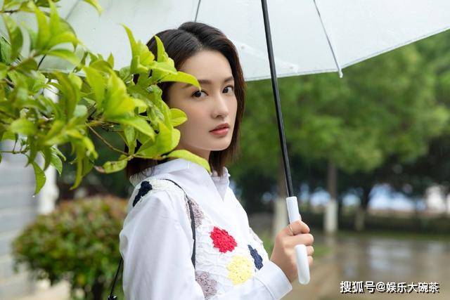 再看她微弯着腰望着镜头,这撑伞的俏皮模样,非常可爱迷人;(右图)李沁