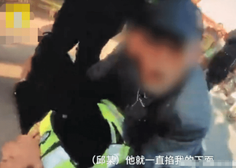 老汉一只手抓着辅警的裆部,而另一只手还在不断的攻击辅警的后脑勺