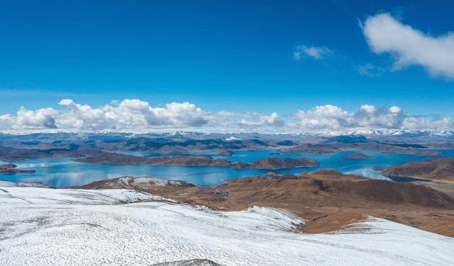 航拍白雪皑皑的鲁日拉山口这里的羊湖观景台可以看到羊湖全貌