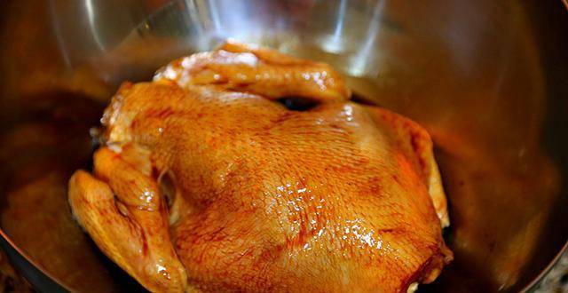 6 葱结不要丢,塞鸡肚子里,把料汁倒进盆里一半,然后剩下的生姜片全倒