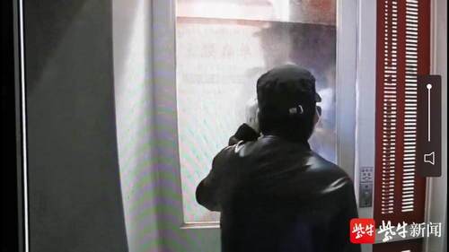 嫌疑人靳某被困住后,趴在玻璃门上看着民警走过来.