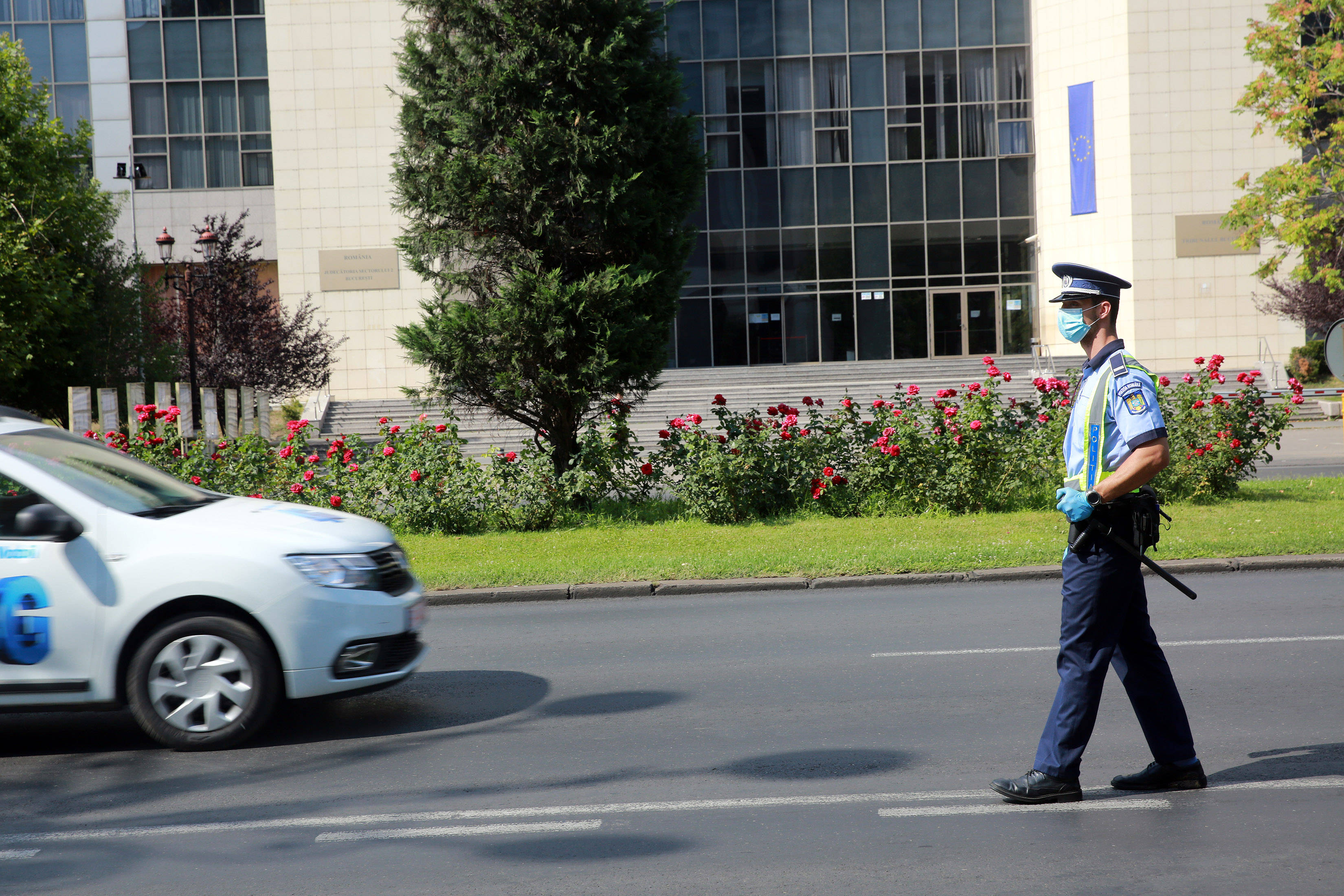 8月1日,在罗马尼亚首都布加勒斯特,警察戴着口罩在路上值勤.