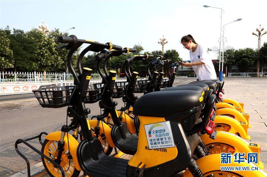 8月4日,市民在涿鹿县街头扫码骑行共享电动车.