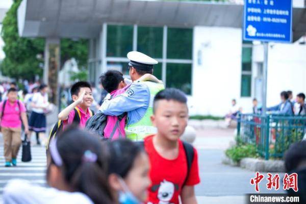 侍东亮|江苏一小学毕业照辅警“C位出道”背后：用爱心在付出