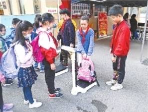 书包|小学生“书包瘦身”校门口过磅