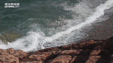 海岸边 海浪肆意地拍打着礁石 激起一层又一层浪花