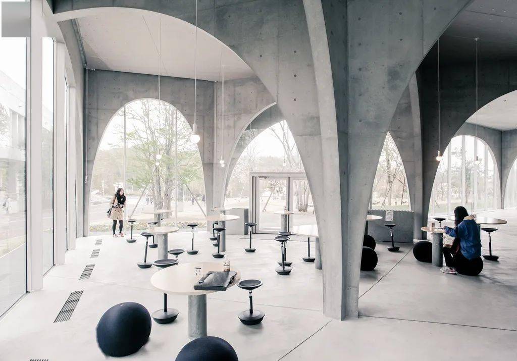 多摩艺术大学图书馆由建筑师伊东丰雄设计,由一系列灰色混凝土拱门