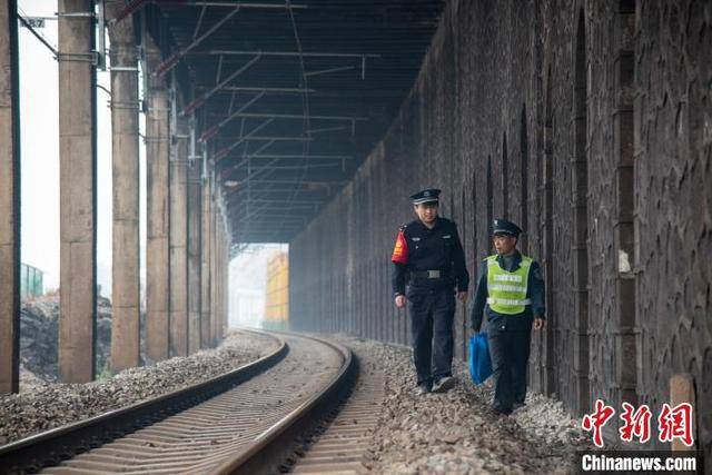 王以照 摄 1月21日,"90后"铁路民警易峰正和护路队员李运武,在广西