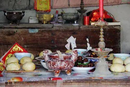 在堂前的大八仙桌子上系上桌帏,摆好香炉,烛台,点燃香烛,供奉祖先.
