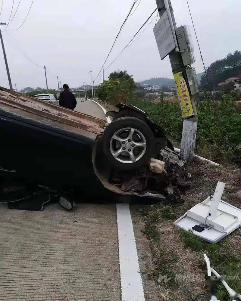 梅县一小车撞到电线杆,小车翻车,电线杆被撞折