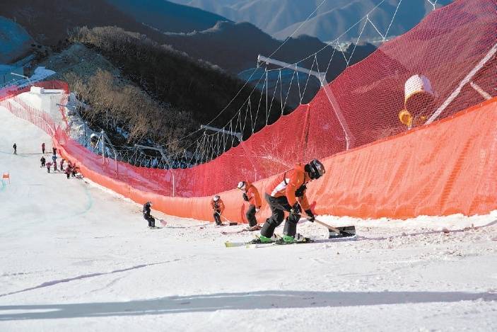 在小海陀山高山滑雪场地,运行团队正在平整赛道.