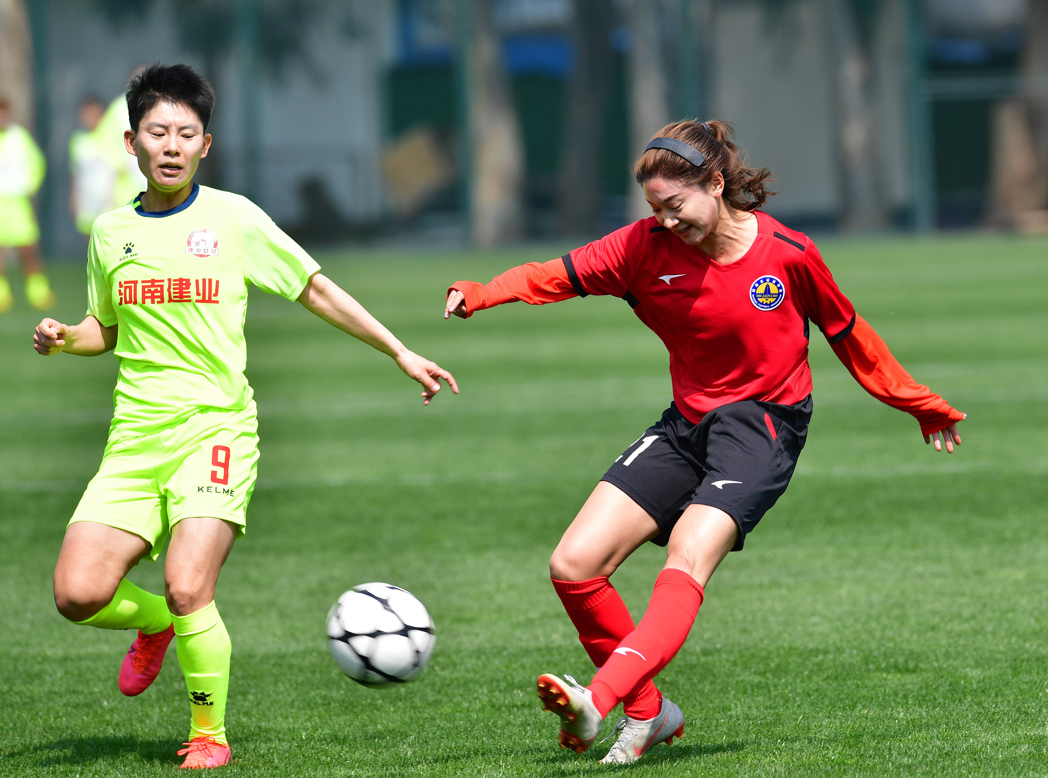 3月25日,陕西女足队球员杨倩(右)在比赛中传球.