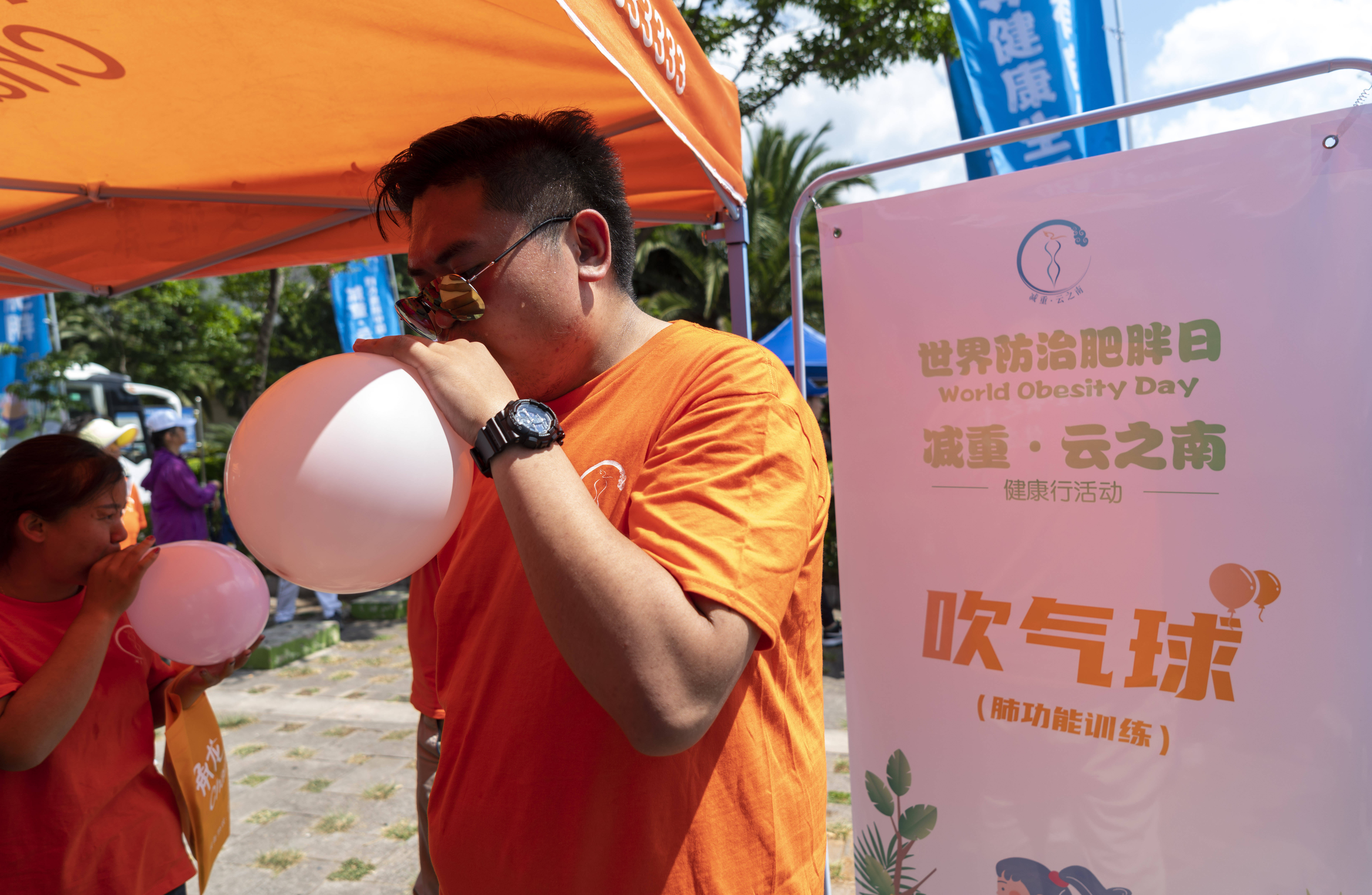 5月9日,一名活动参与者在吹气球.