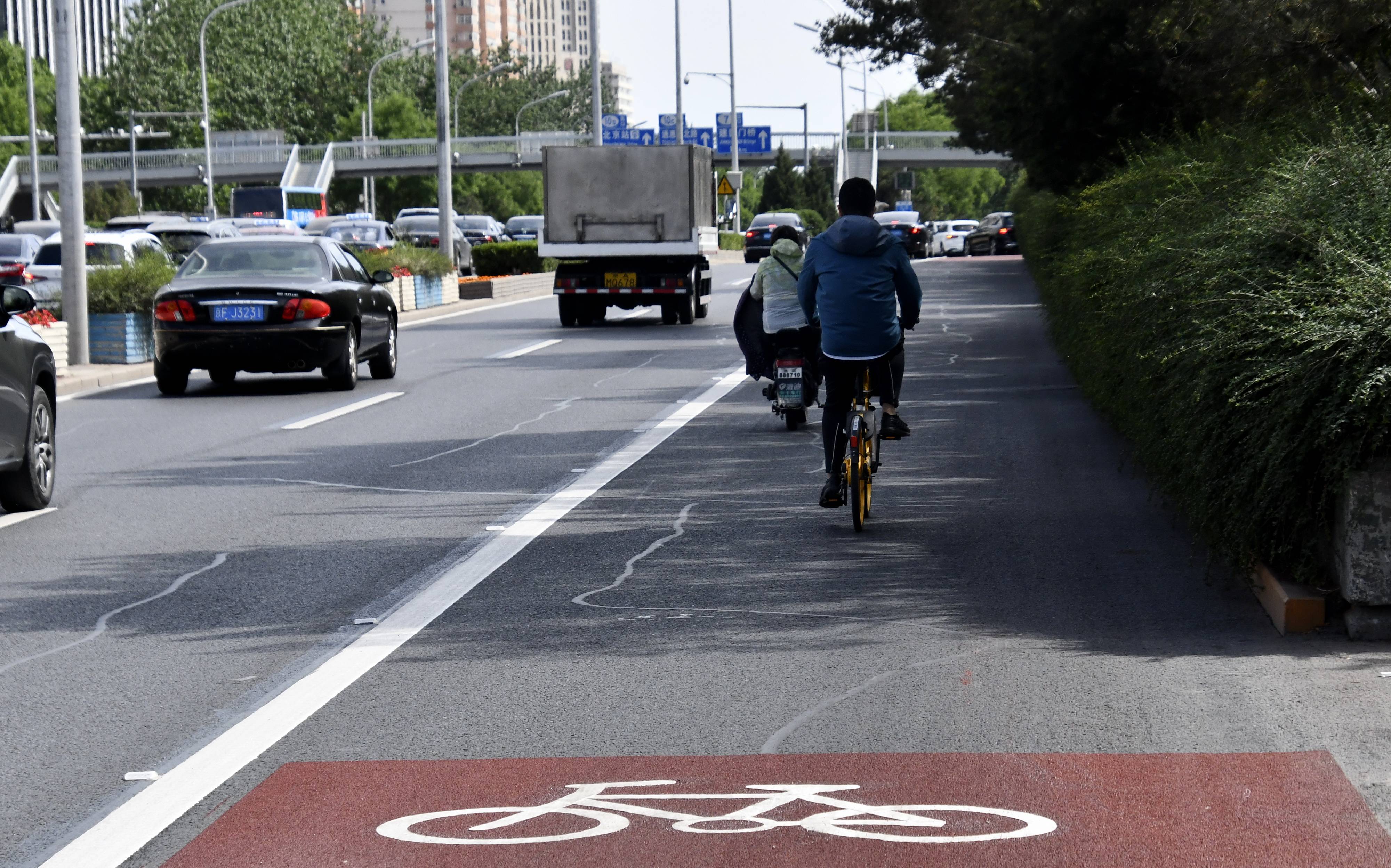 5月16日,市民在自行车道标识鲜明的北京东二环辅路上骑行.