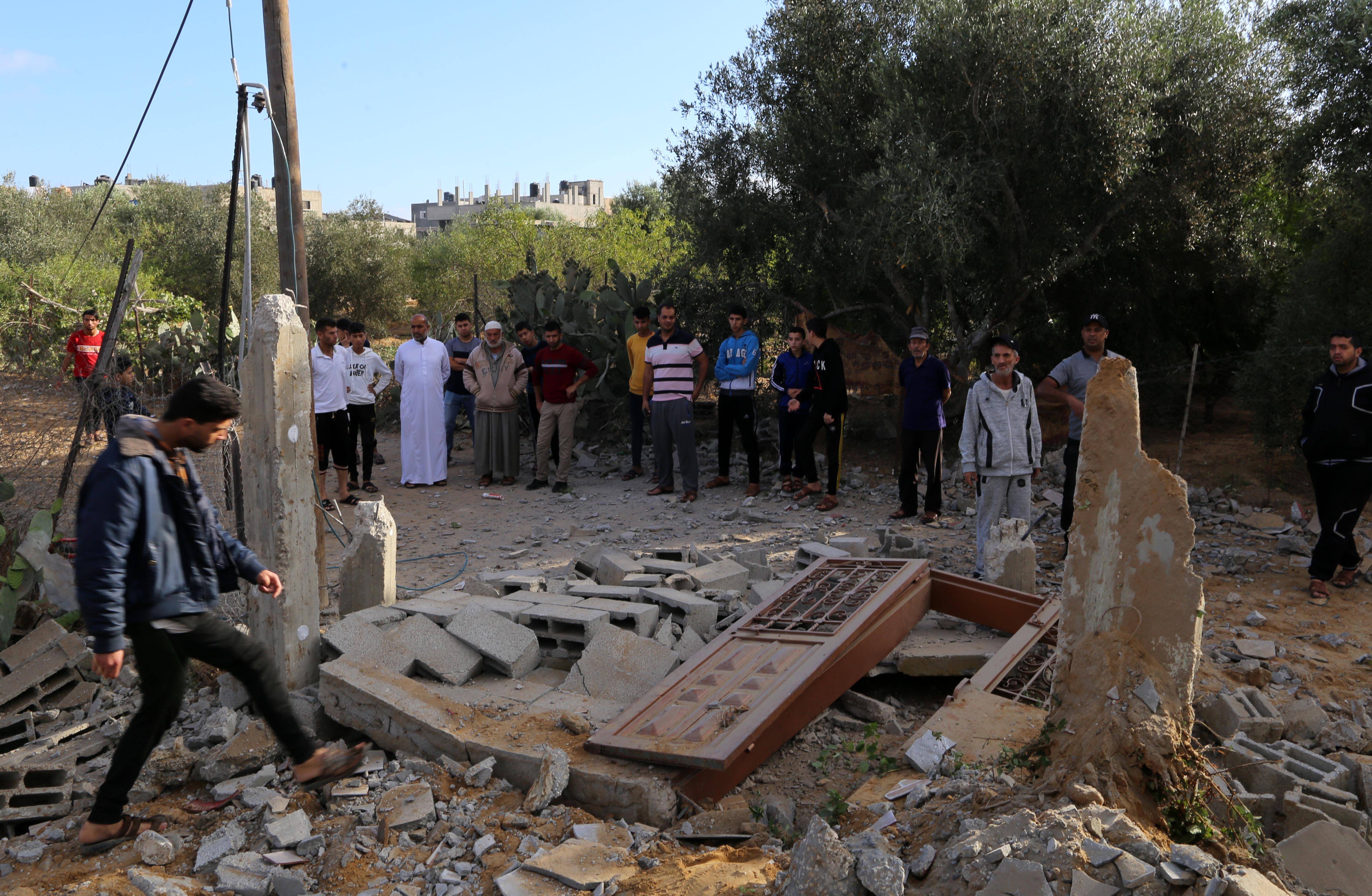 5月18日,巴勒斯坦人在加沙地带城市汗尤尼斯查看被以军空袭摧毁的一处