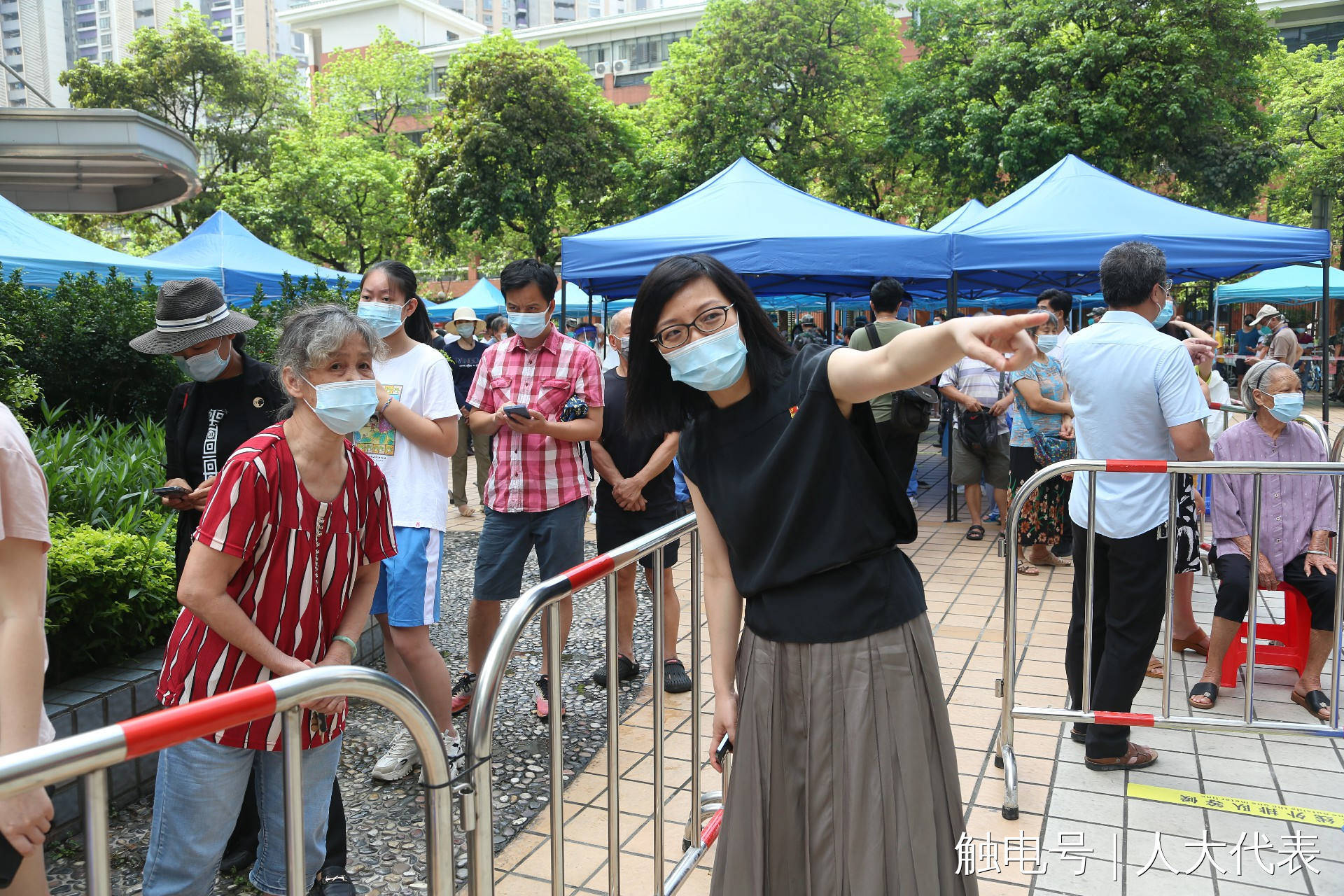 随后,池锦玲代表和其他志愿者一起维持排队居民的秩