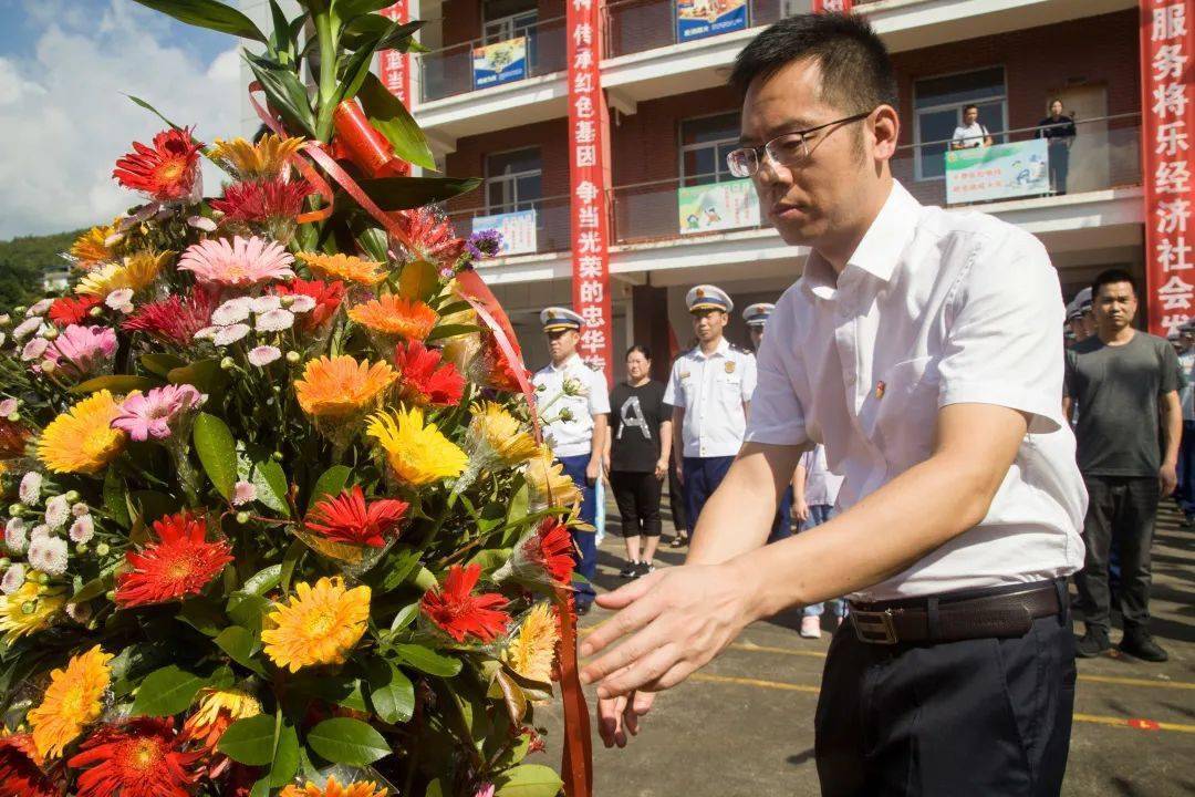 县委常委陈成权,支队政治部主任温北尧为花篮整理缎带"忠华服务队"和"