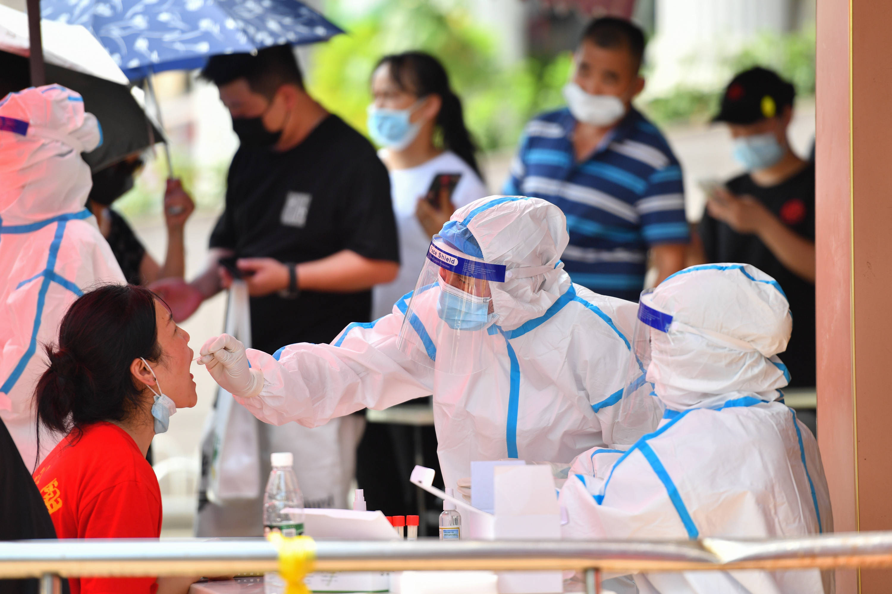 7月31日,在长沙市天心区赤岭路街道南大桥社区核酸检测点,工作人员对