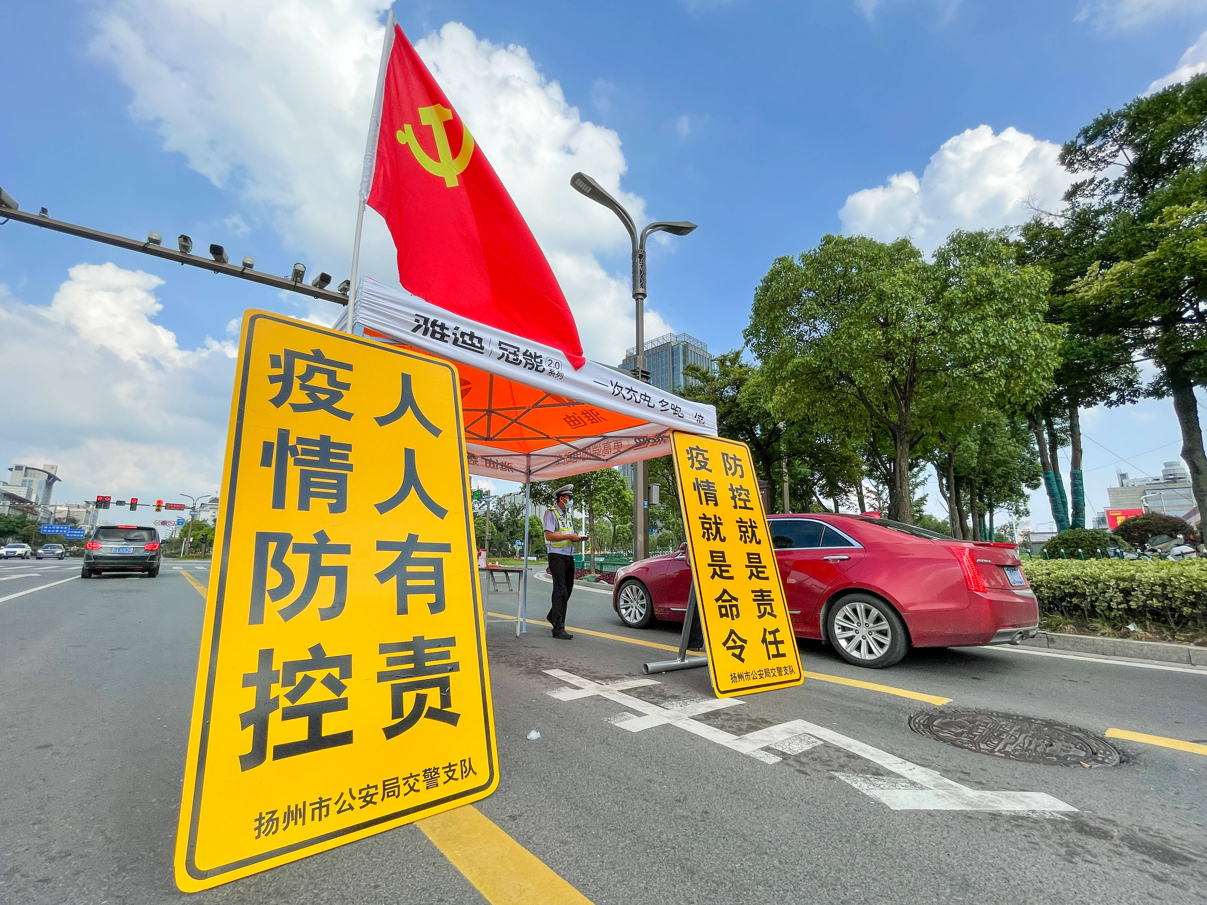 在扬州市主城区主干道上一处疫情防控检查点,交警检查过往车辆人员的"