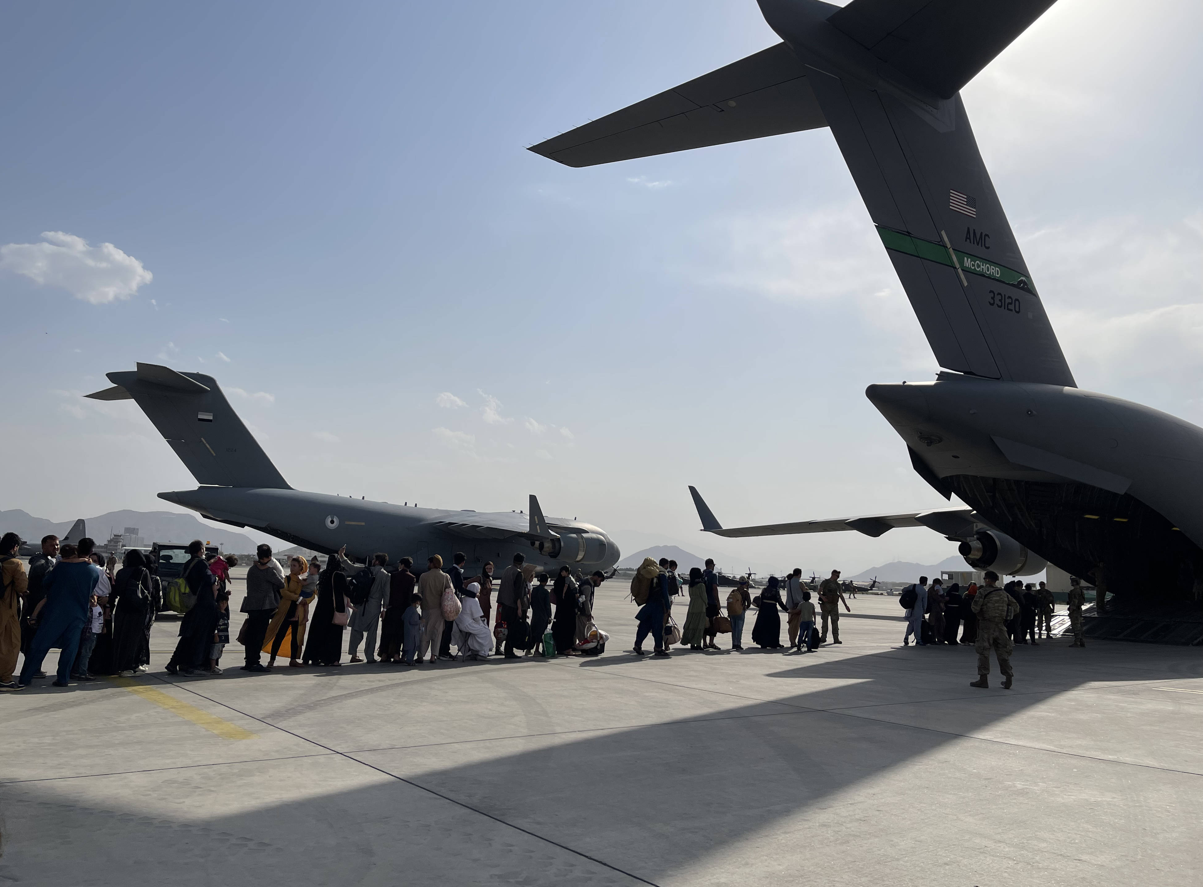 8月22日,人们在阿富汗首都喀布尔国际机场排队登上美国军用飞机离开.