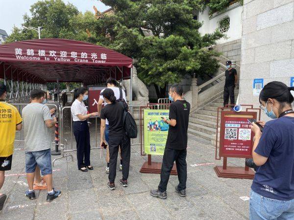 在黄鹤楼景区,游客排队扫码入园,线上打卡"诚信守诺 文明出游.