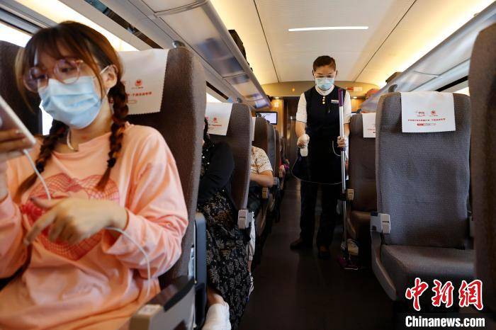 列车乘务员胡晶晶正在列车车门外迎接旅客的到来. 殷立勤 摄