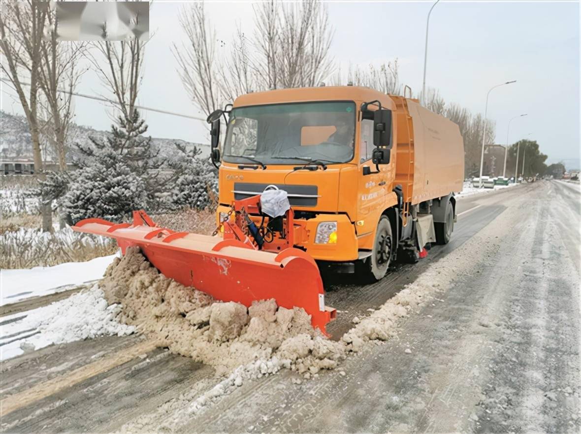 公路养护职工正驾驶铲雪车铲除路面冰雪