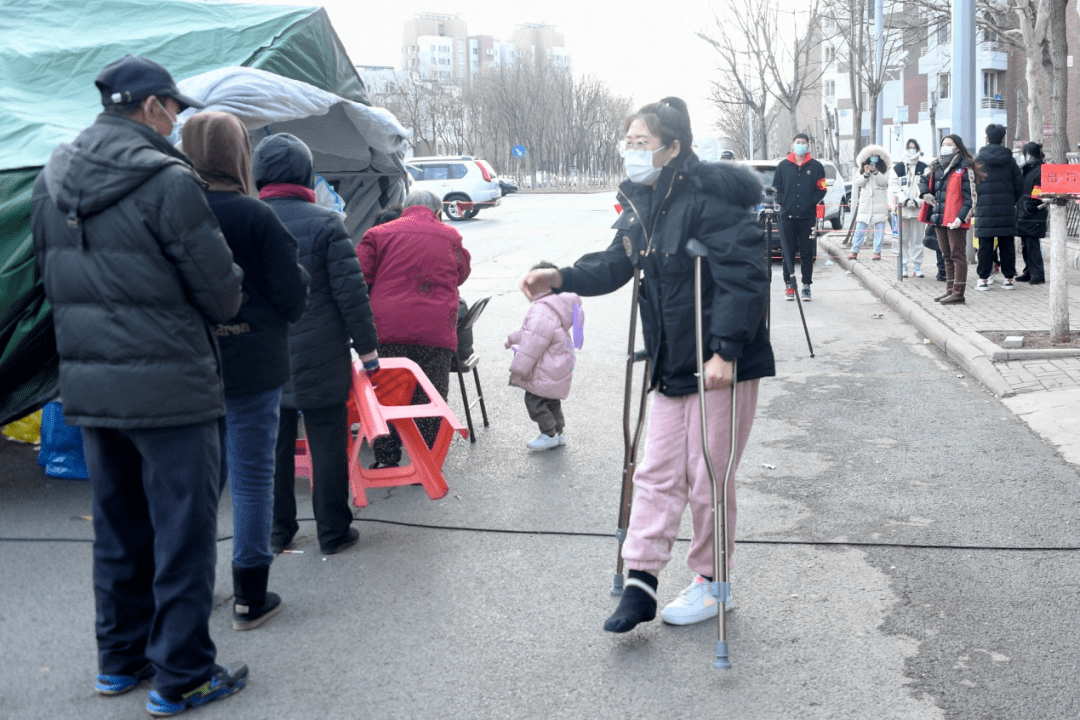 在核酸检测采样点,记者看到华明街道第二社区党委书记刘云晶拄着拐杖