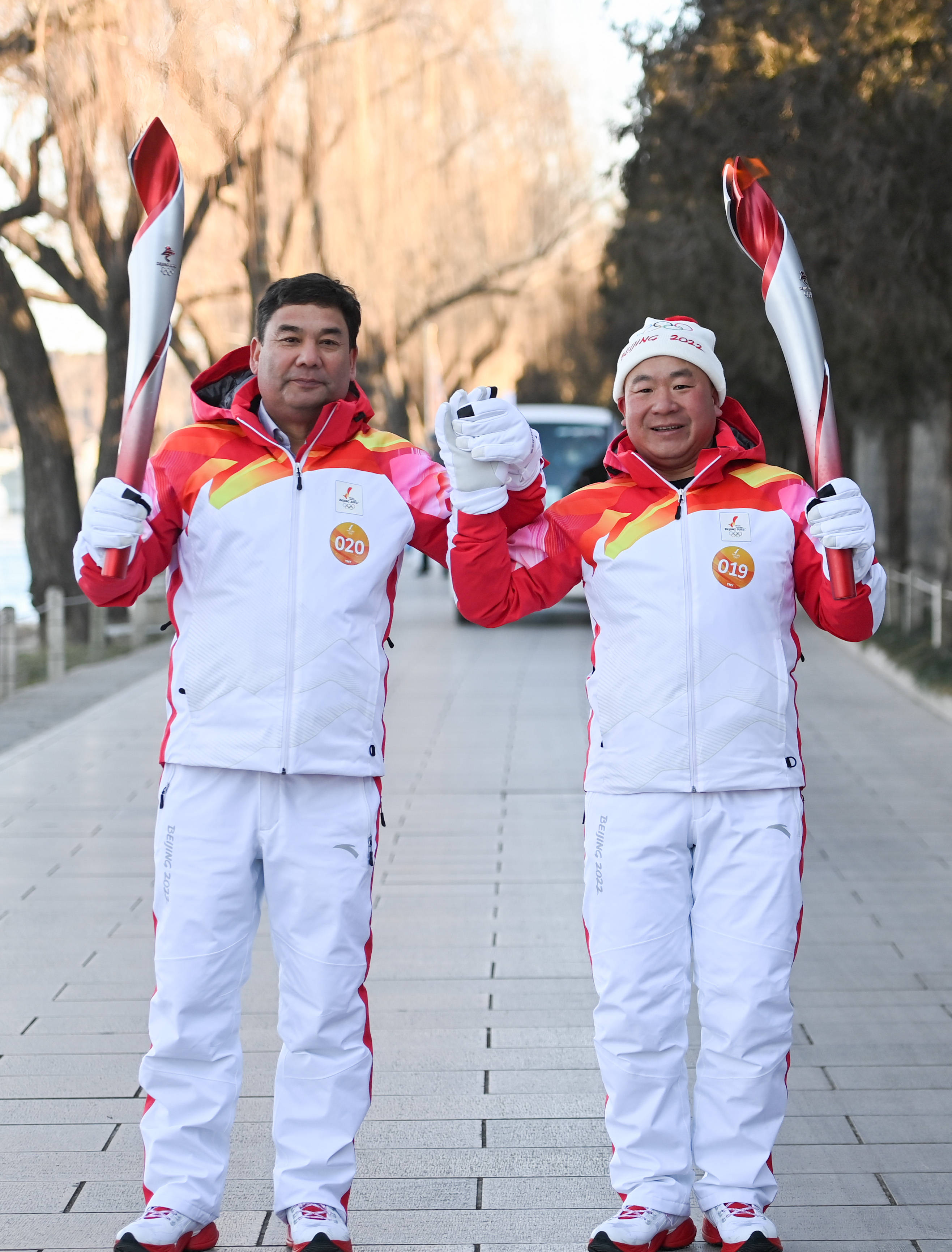 2月4日,火炬手赵新录(右)与库尔班·尼亚孜进行火炬传递.