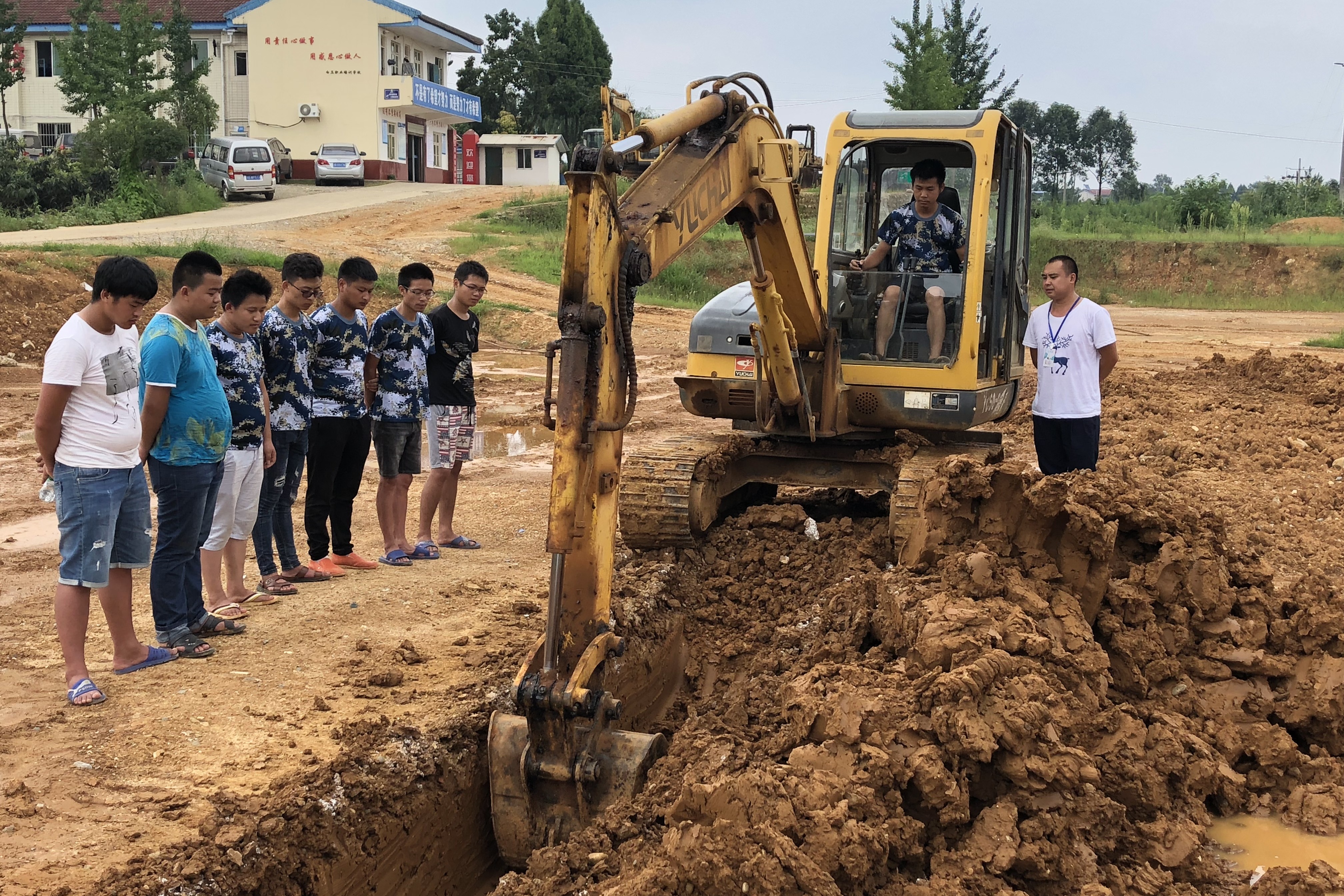 实拍教练给学员讲解挖掘机挖沟技巧