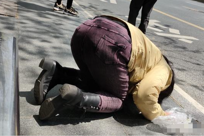 黑龙江一女子跪地乞讨遭斥责大妈是假的就赶紧走别影响市容