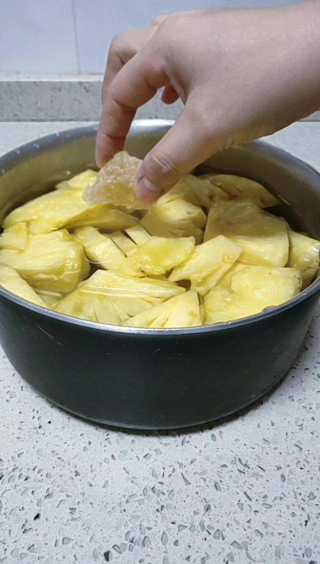 3.将菠萝捞出放到汤锅中,加入适量的水和冰糖.