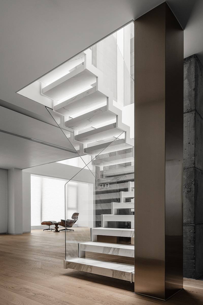 位移的雪花白岩板楼梯重新定义格局新的过渡空间和中央楼梯贯穿公寓的