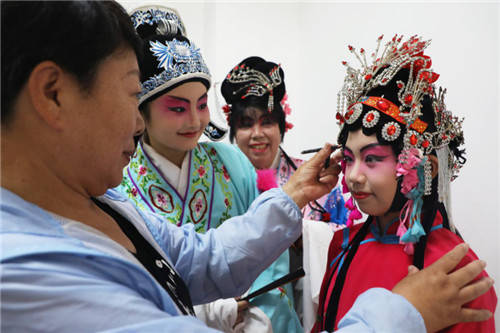 7月23日,在河北省唐山市丰润区文化馆,评剧票友在演出前化妆.