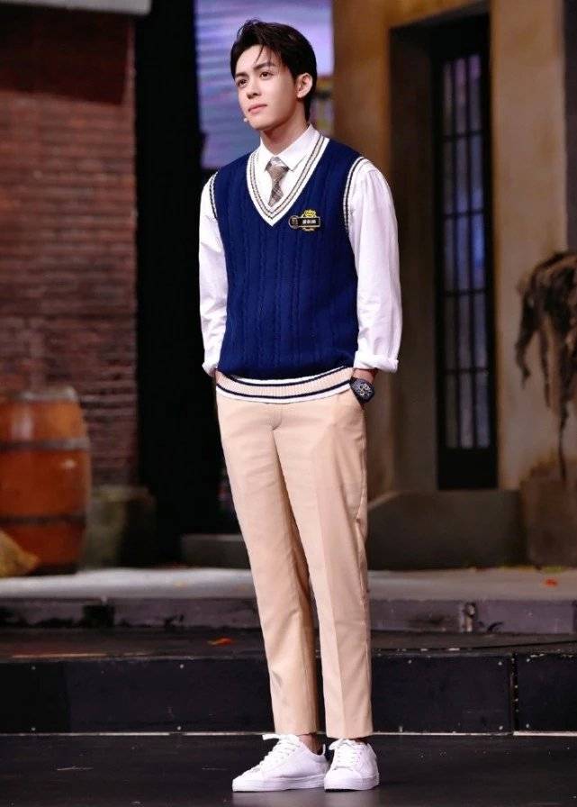 曾舜晞穿的是一件白色衬衫,搭配蓝色针织马夹,还有卡其色的西裤,脚踩