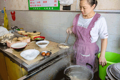老板娘从铁盘中数上十来个馄饨放入滚着水的锅中,不消一分钟馄饨便