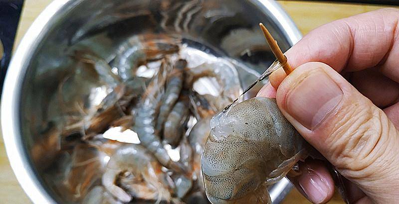 上稍微用点力把虾线挑出来,再朝虾头方向轻轻地用力把虾线慢慢拽出来