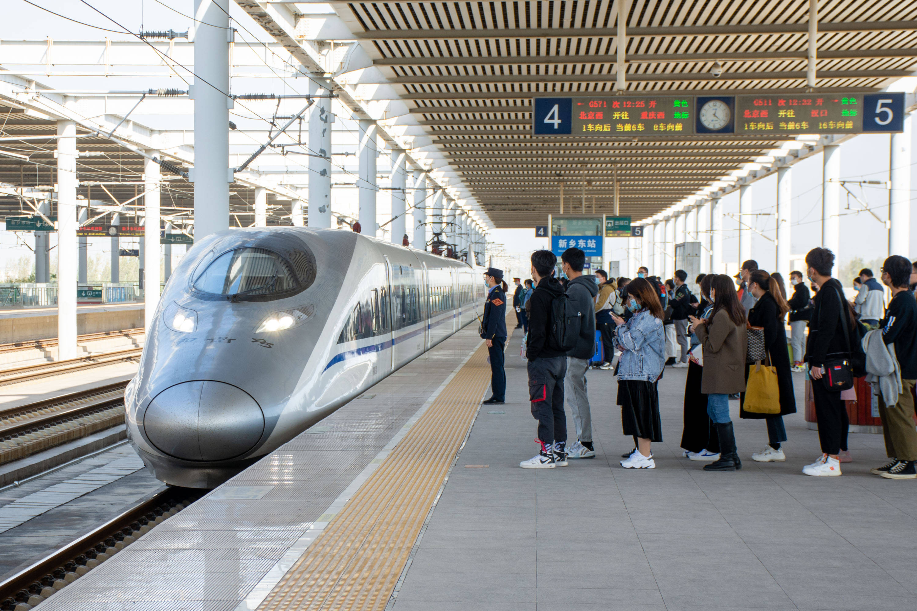 图为高铁从北京开过来到站台时的情景,乘客等车时不能越过黄线