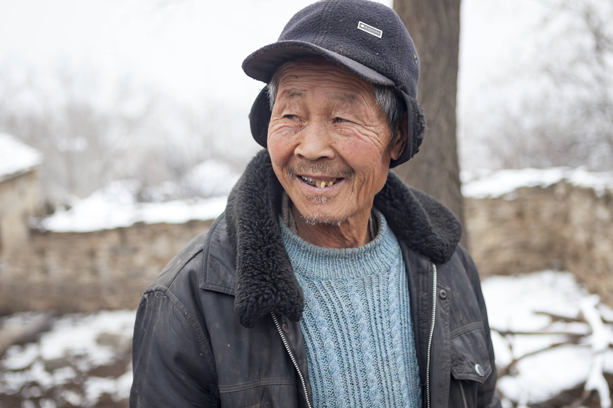小山村下雪了二位留守老人在照料家里的牛