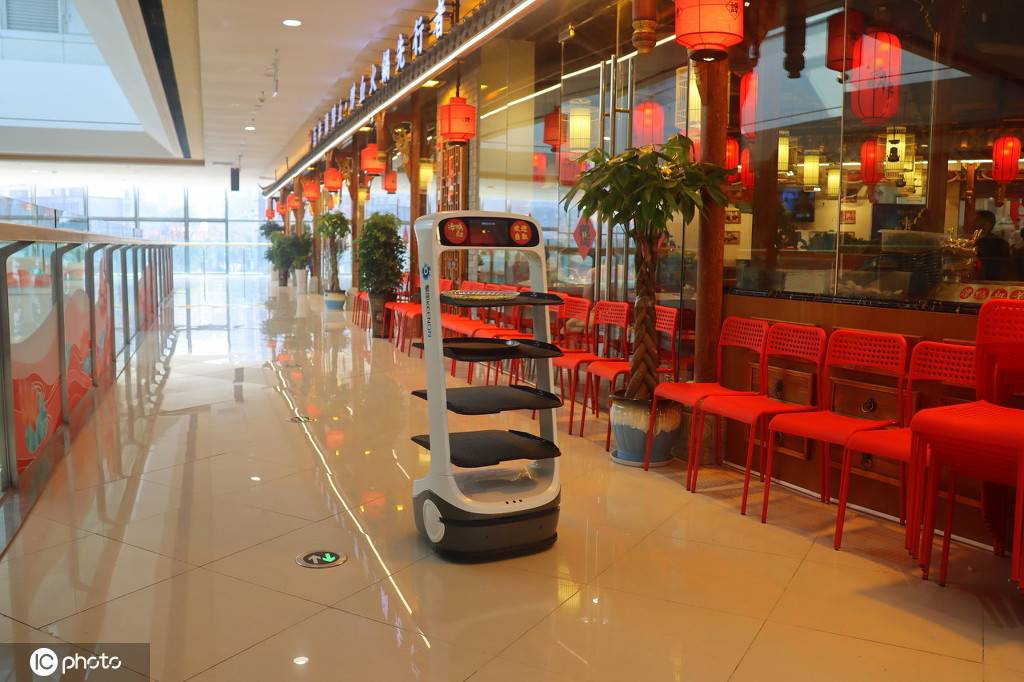 夷陵万达广场内谭鸭血老火锅餐厅门前,一台高科技机器人替代服务员