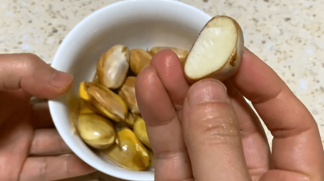 其实这个果核也非常的好吃,它比板栗还香,我们先把果核剥出来,把果肉