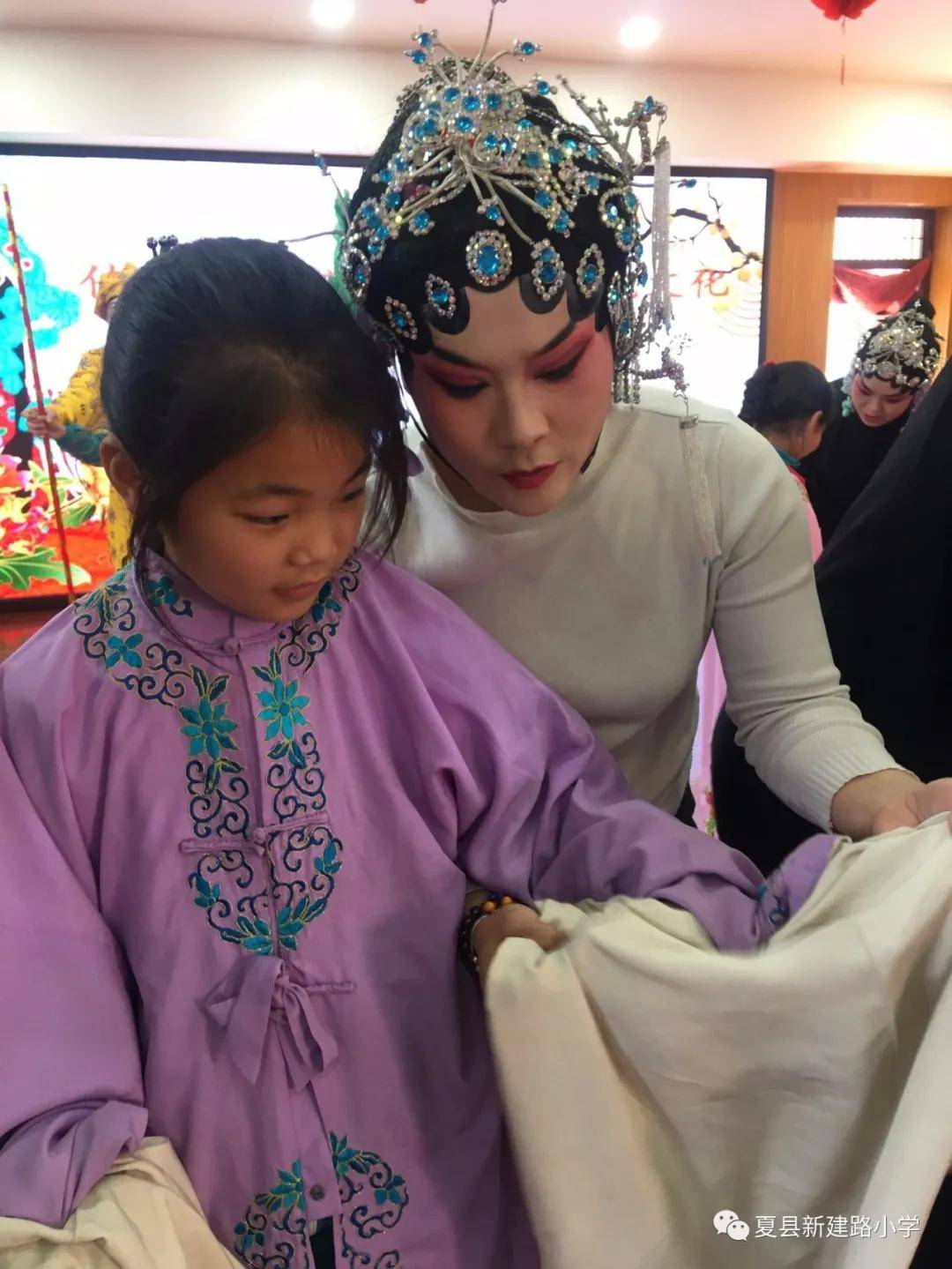 演员向孩子传授抛水袖的要领及如何将水袖抖得恰到好处,如何以目传情