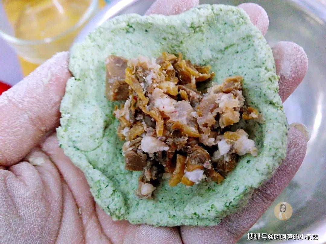 轻轻压扁,形成小面饼,将每个青团生坯放在提前泡发好剪成小片的粽叶上