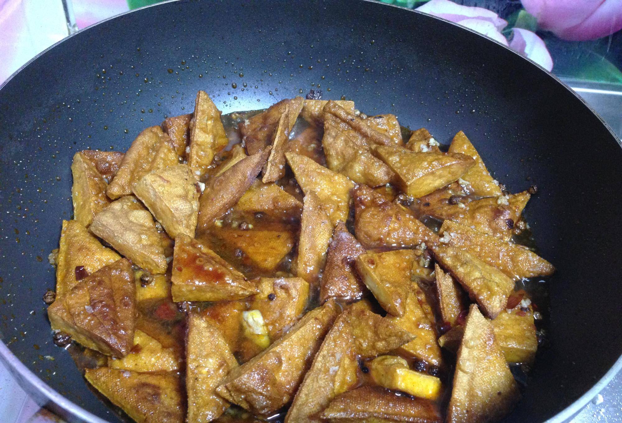 倒入豆干,白糖,生抽一起大火煮开转小火煮20分钟转大火收干汁,撒孜然