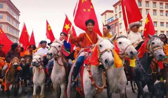 民族|丁真骑白马上街超有排面!穿藏袍举国旗意气风发,笑容好有感染力