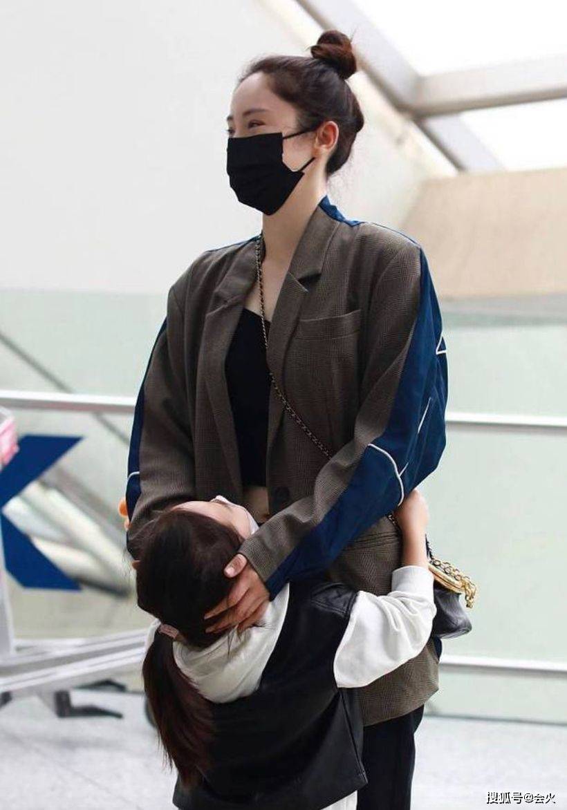 双手41岁董璇带女儿走机场！穿露腰短上衣不怕冷，被女儿环抱好亲密