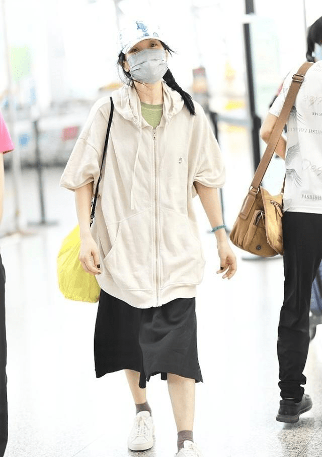 个性 周迅走机场挺“张扬”，穿棕色星空小半袖，脚上穿的粉袜子更抢镜