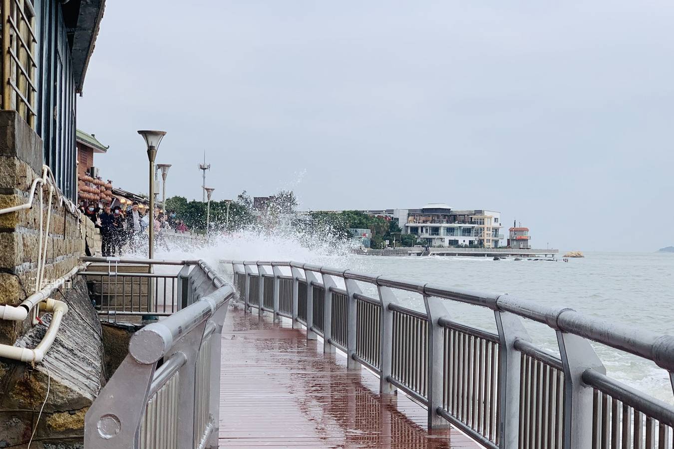 厦门版“小钱塘江”，海浪拍打木栈道，游客冒着淋湿来回跑