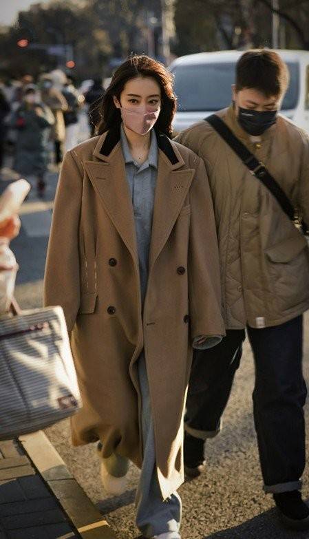 张小斐 张小斐是行走的衣架子,一身黑色大衣手拿鲜花,美得很有氛围感